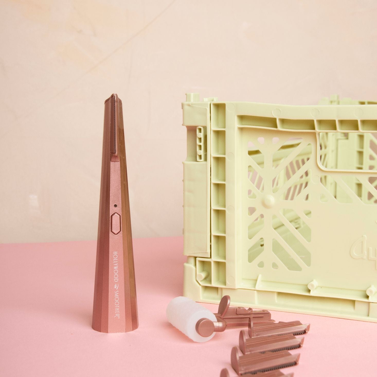 Smoother with attachments on a pink surface with a light green crate in the background